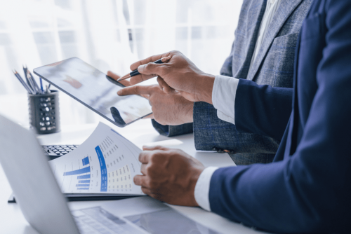 business tax planning, law firm in West Monroe, LA at Niswanger Law. Close-up of two professionals reviewing financial graphs and data on a tablet.